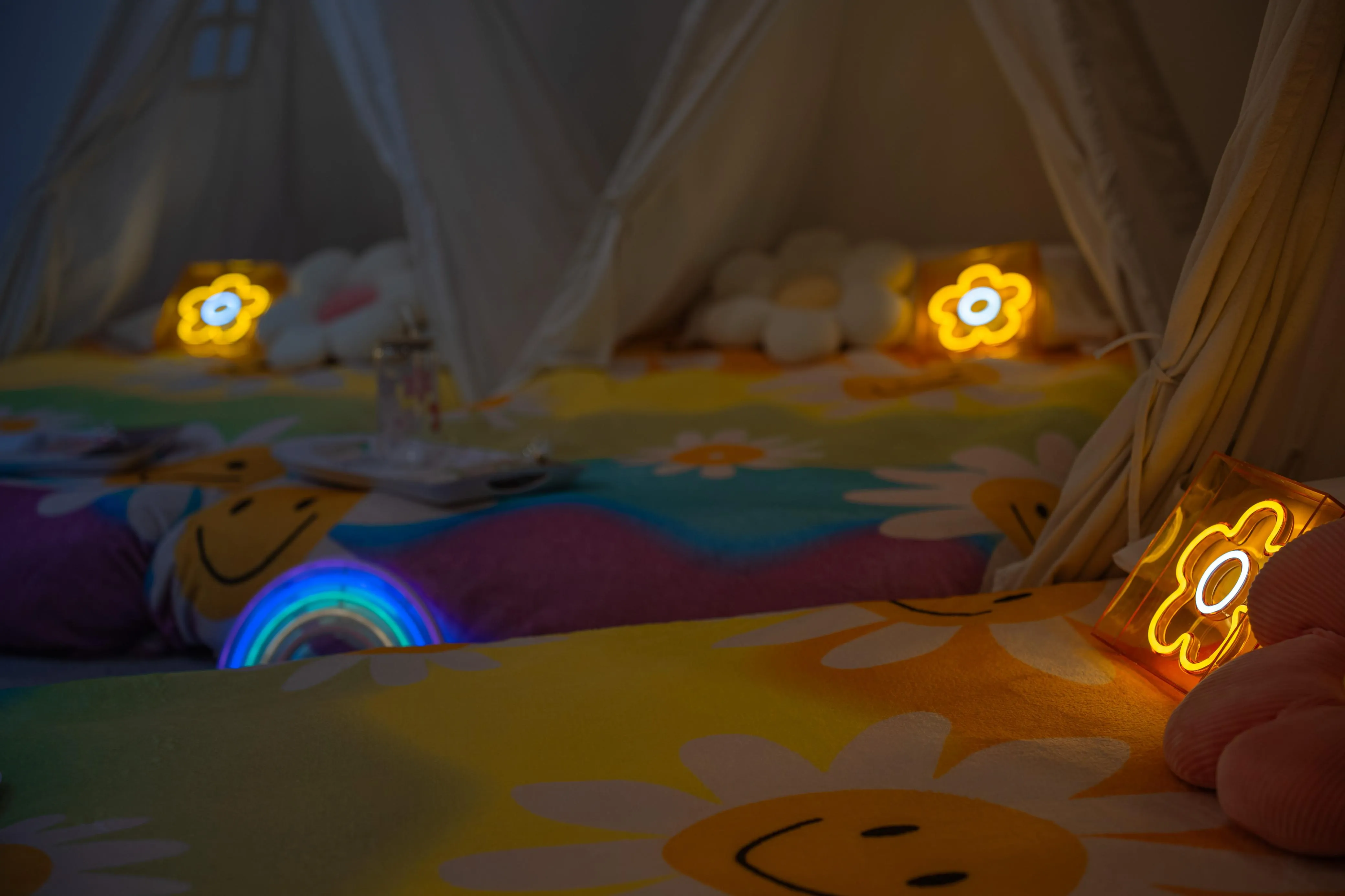 Cream sleepover tents with flower blankets and glowing flower lights.